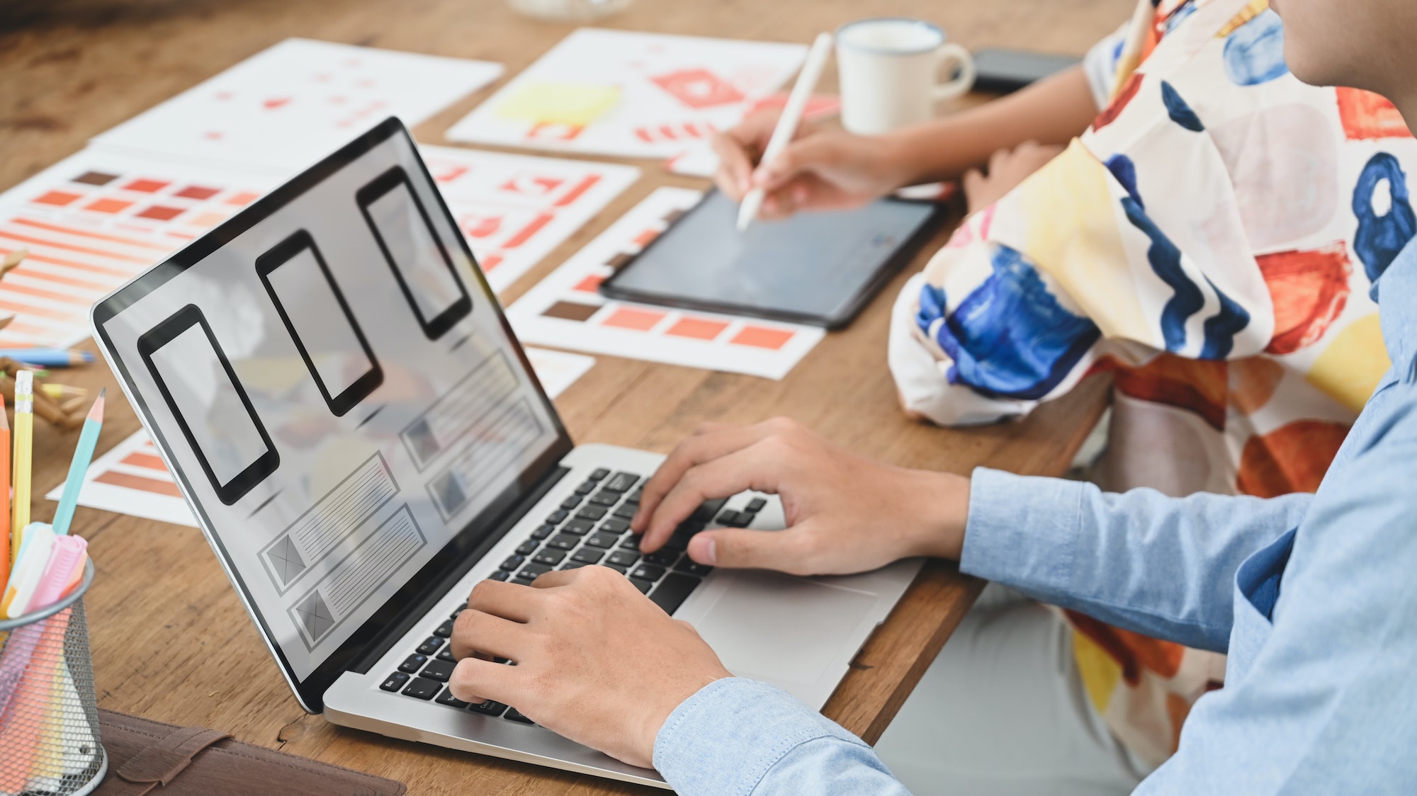 Cropped image of two people is using a computer laptop with an interface icon.